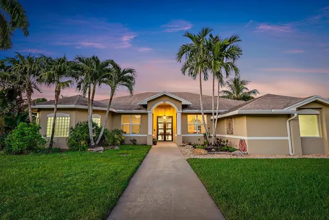 a front view of a house with a garden and yard