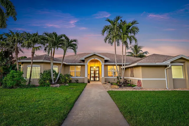 a front view of a house with a garden and yard