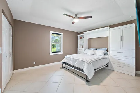 a bedroom with a bed and a ceiling fan
