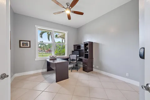 a view of a workspace with furniture and a window