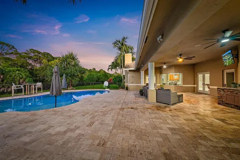 a view of a house with swimming pool and sitting area
