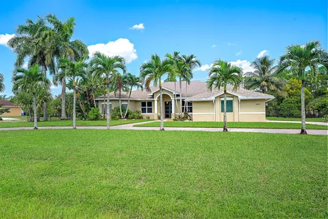 a front view of a house with a yard and trees