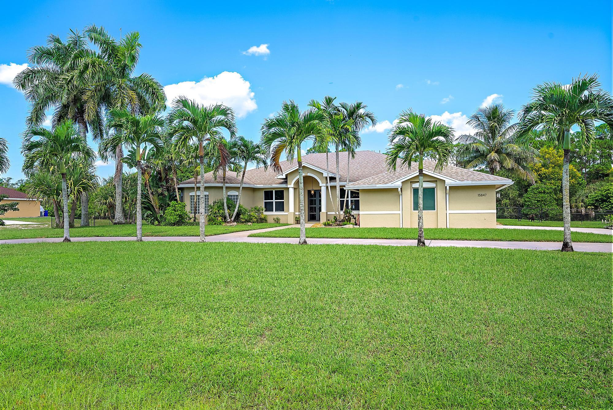 15847 86th Road North Loxahatchee, FL 33470 - Photo 29 of 45 a front view of a house with a yard and trees