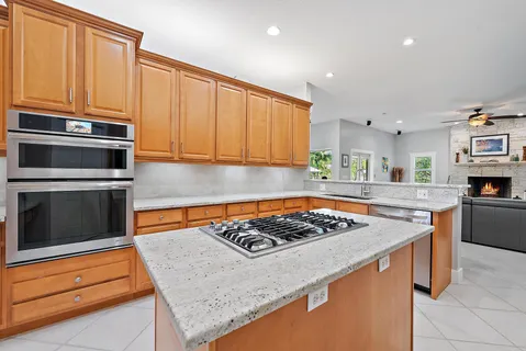 a kitchen with stainless steel appliances granite countertop a stove a sink and a microwave