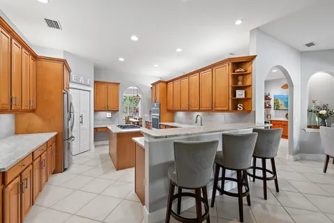 a kitchen with stainless steel appliances granite countertop table chairs sink and window