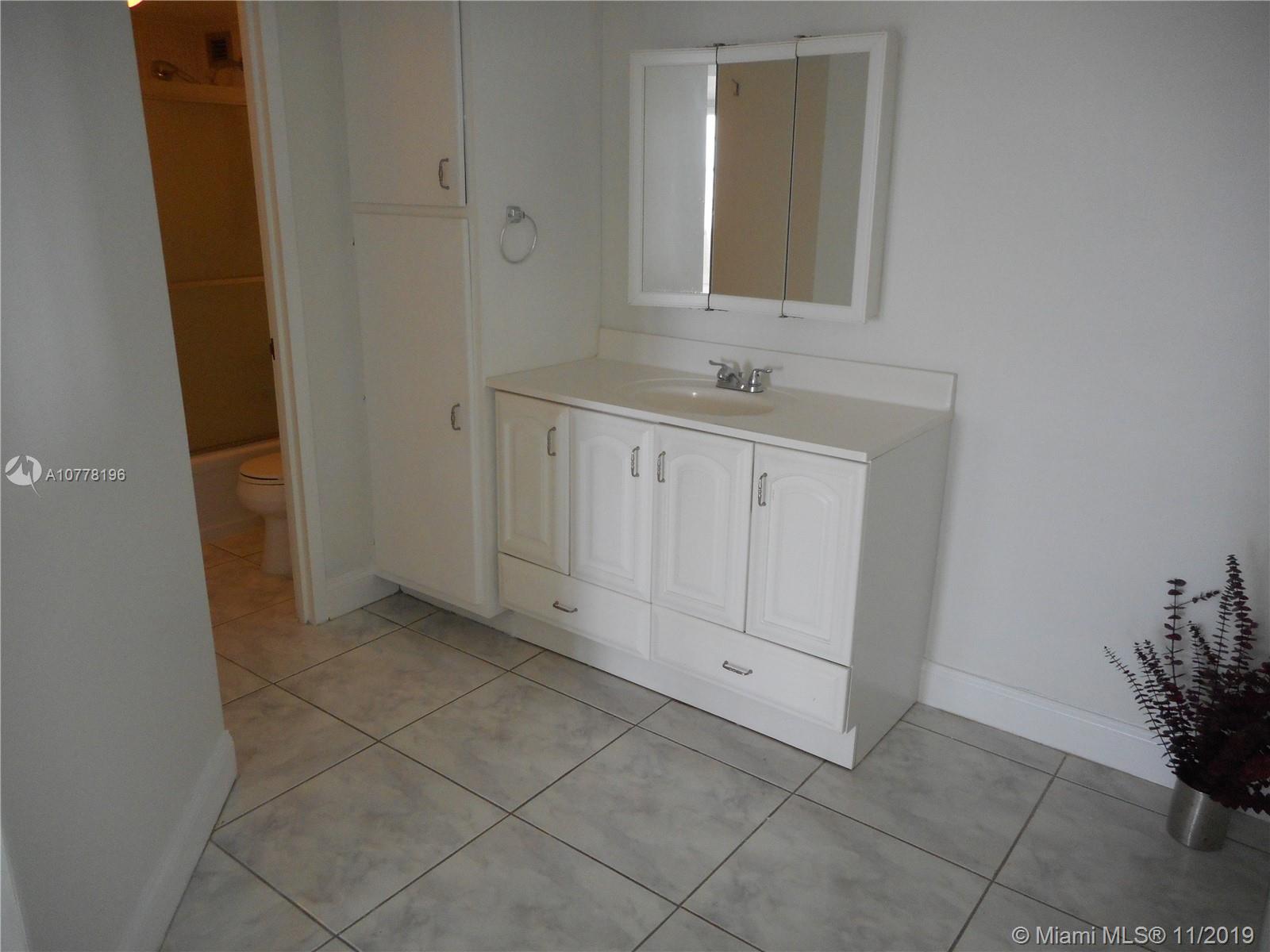 9511 Collins Avenue, Unit 1209 Surfside, FL 33154 - Photo 11 of 20 a bathroom with a sink and cabinets
