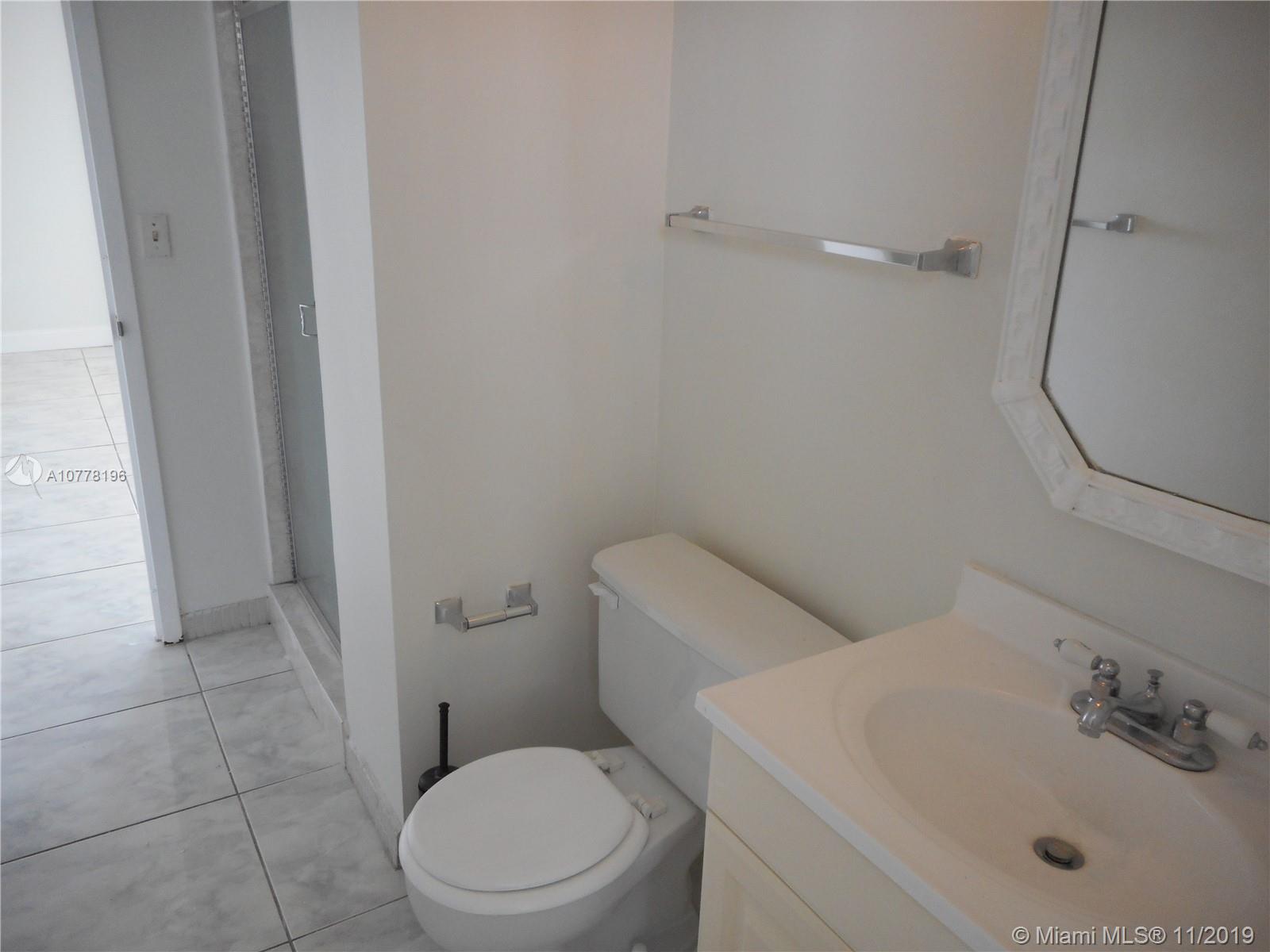 9511 Collins Avenue, Unit 1209 Surfside, FL 33154 - Photo 12 of 20 a white toilet sitting next to a bathroom sink