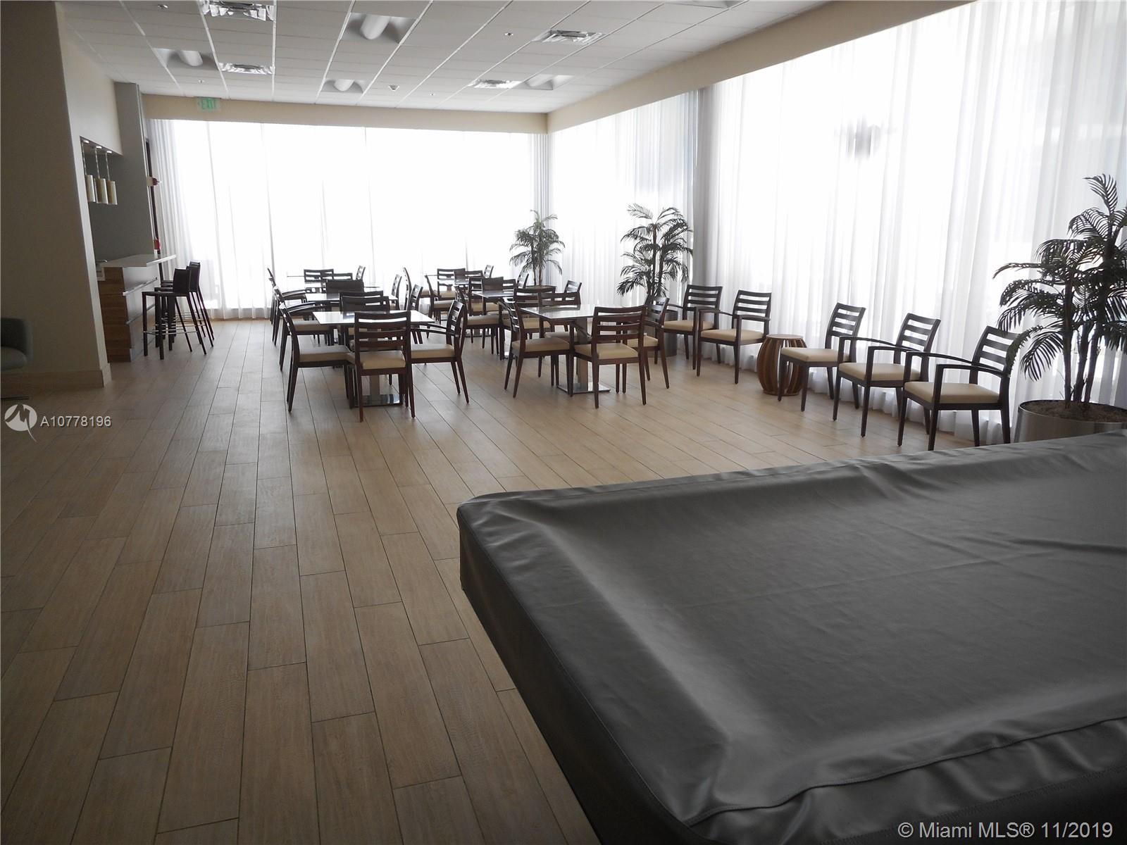 9511 Collins Avenue, Unit 1209 Surfside, FL 33154 - Photo 17 of 20 a view of a dining hall with furniture and a large window