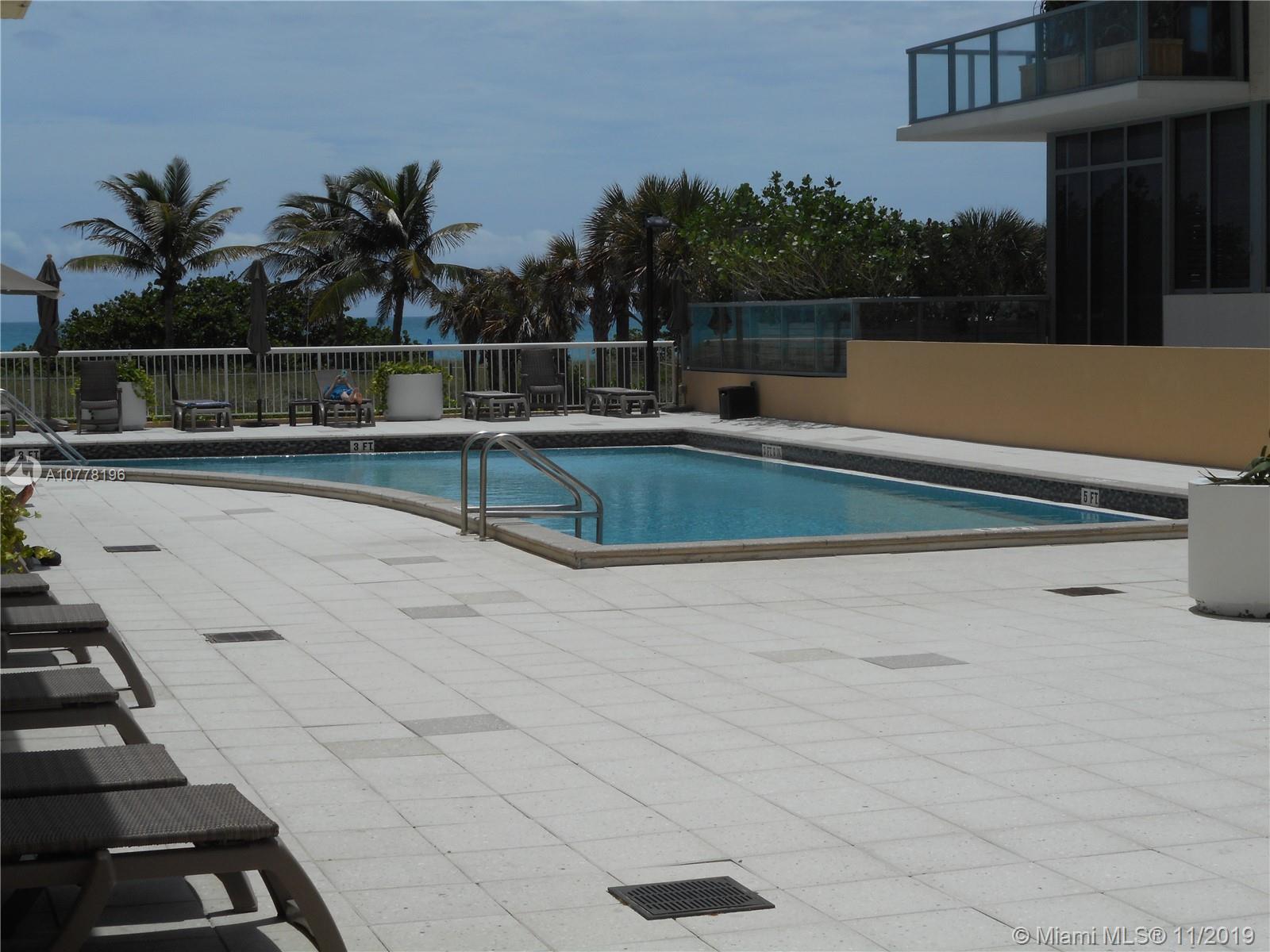9511 Collins Avenue, Unit 1209 Surfside, FL 33154 - Photo 18 of 20 a view of swimming pool with seating space and trees in the background