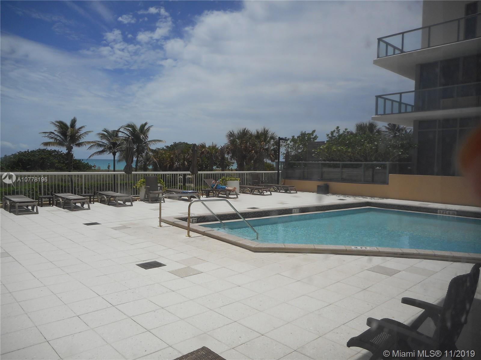 9511 Collins Avenue, Unit 1209 Surfside, FL 33154 - Photo 19 of 20 a view of a swimming pool and lounge chair