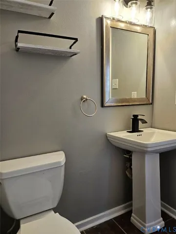 a bathroom with a toilet a sink and mirror