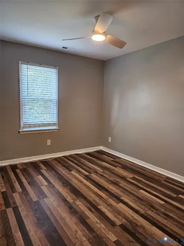 a view of a room with wooden floor and chandelier fan