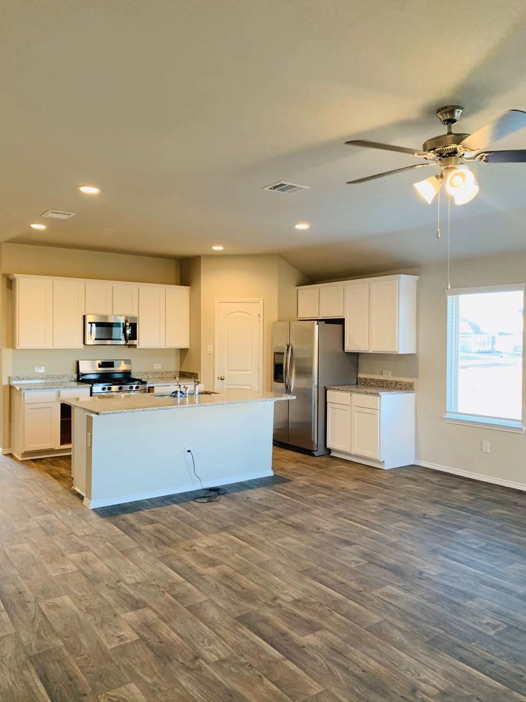 22730 Busalla Trail Katy, TX 77449 - Photo 4 of 10 a large kitchen with stainless steel appliances kitchen island a large counter top and a stove top oven
