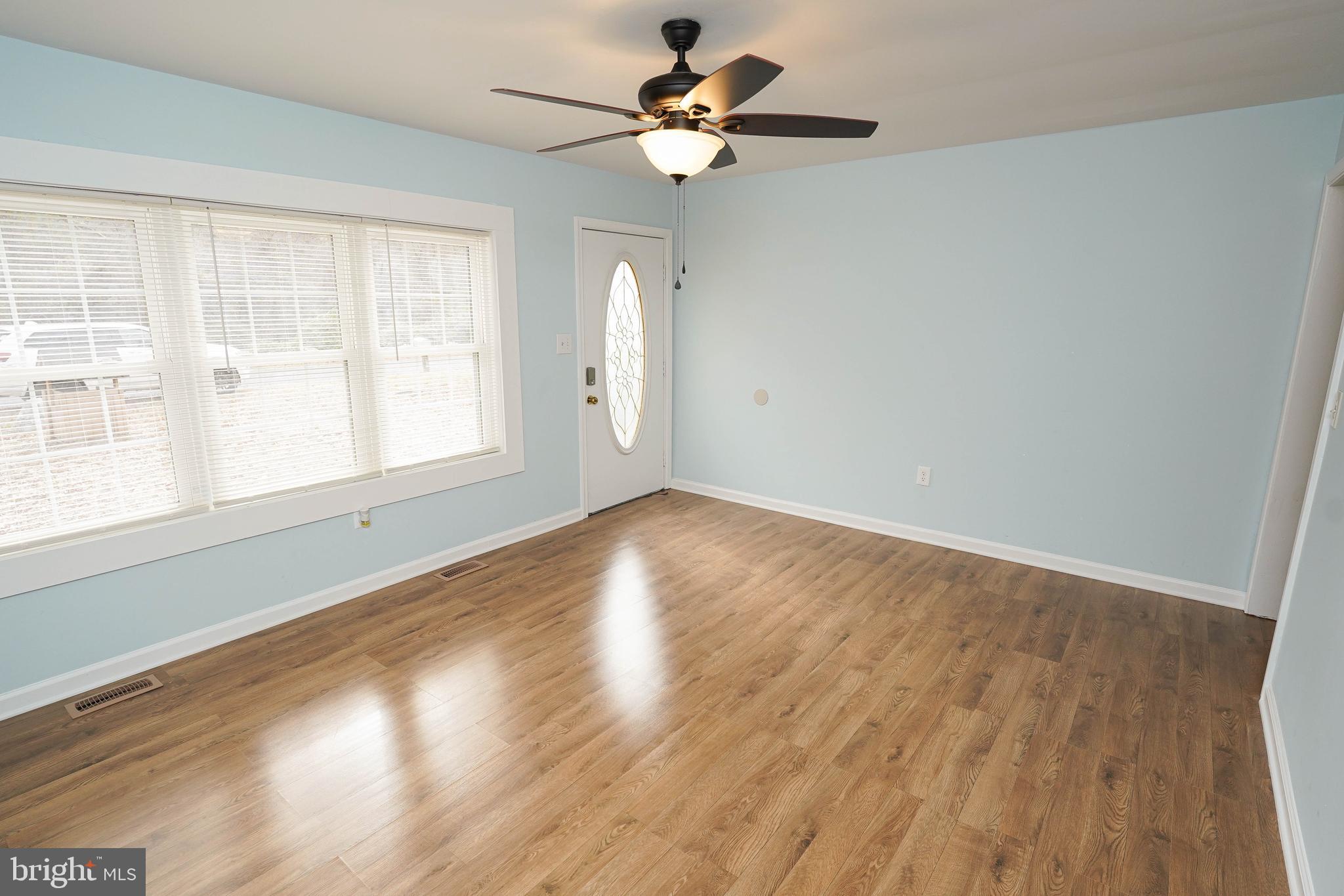 28144 Stanford Road Eden, MD 21822 - Photo 3 of 31 an empty room with wooden floor chandelier fan and windows