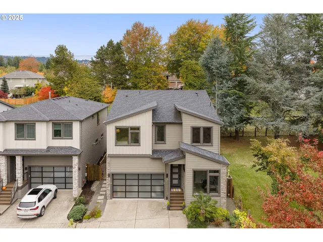a front view of a house with glass windows and trees