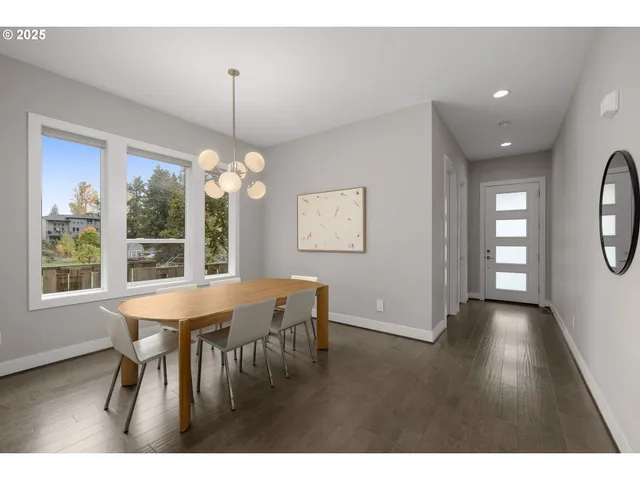 a dining room with wooden floor a chandelier a wooden table and chairs
