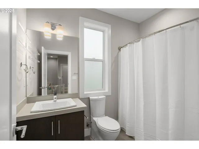 a bathroom with a sink vanity mirror and toilet