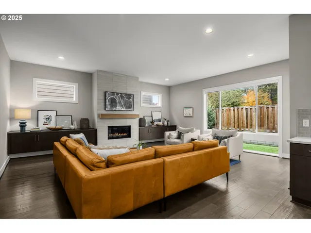 a living room with fireplace furniture and a wooden floor