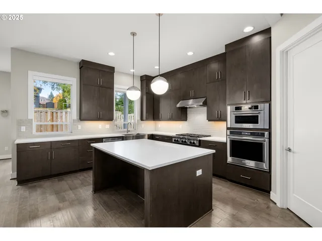 a kitchen with kitchen island a sink stainless steel appliances and cabinets
