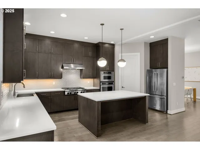 a kitchen with stainless steel appliances granite countertop a sink a stove and a refrigerator