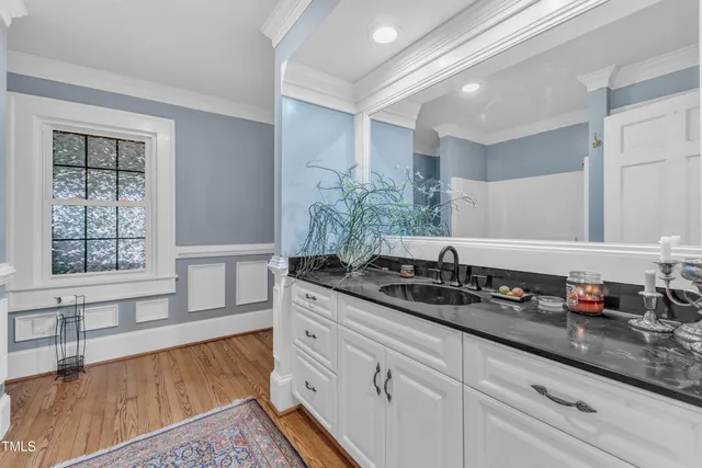 a kitchen with stainless steel appliances granite countertop a stove chairs cabinets and wooden floor