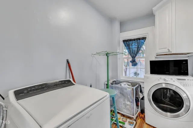 a living room with furniture and a dining table with wooden floor