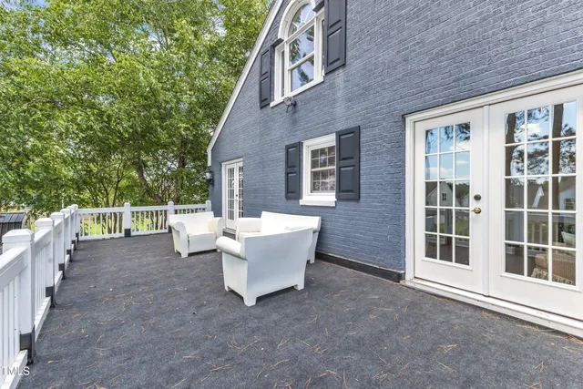 a view of a house with a large window and wooden fence