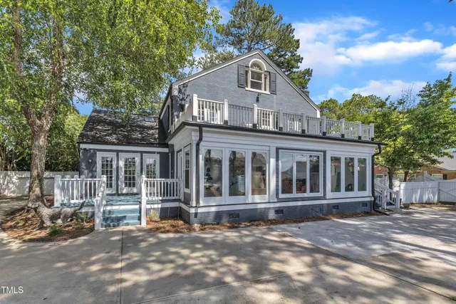 a view of a house with backyard and sitting area