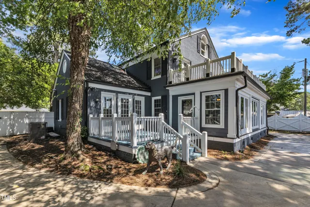 a view of house with a yard and potted plants