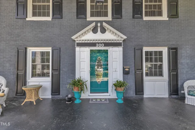 a view of a brick house with potted plants and a table