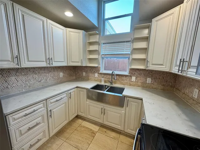 a kitchen with granite countertop white cabinets and sink