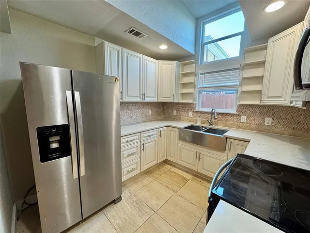 a kitchen with a refrigerator sink and cabinets
