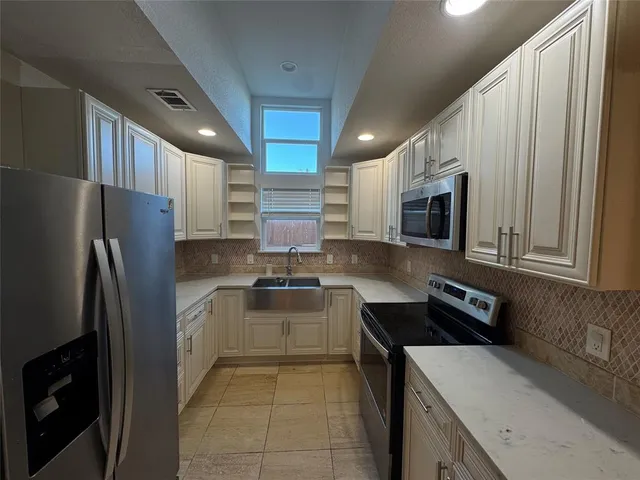 a kitchen with a refrigerator sink and stove top oven