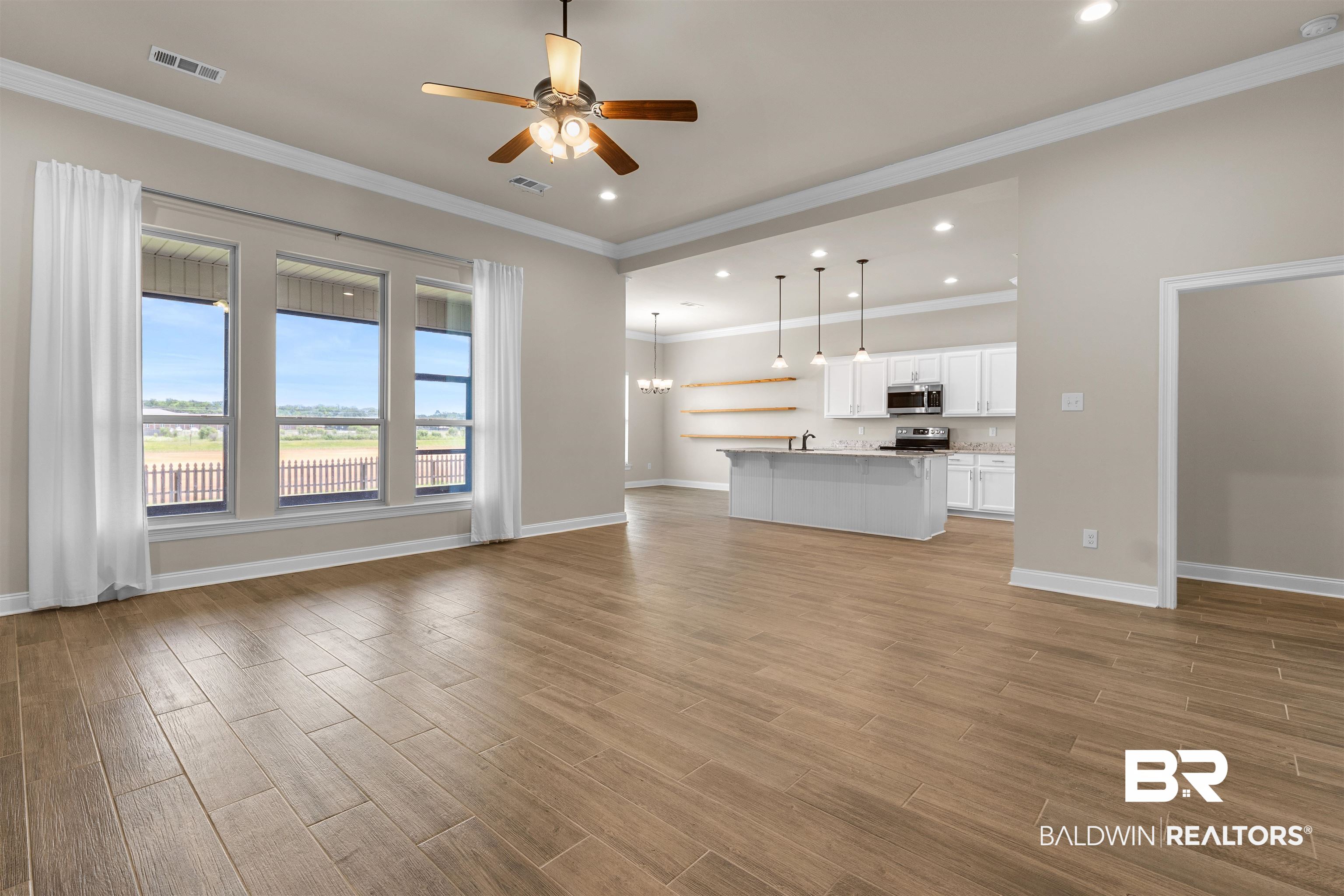 991 Dalton Circle Foley, AL 36535 - Photo 2 of 35 Unfurnished living room featuring light wood-type flooring, ceiling fan, recessed lighting, crown molding, and a chandelier