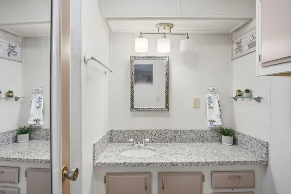 a bathroom with a granite countertop sink and a mirror