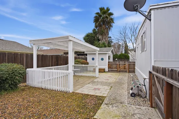 a view of a porch with a bench and wooden fence