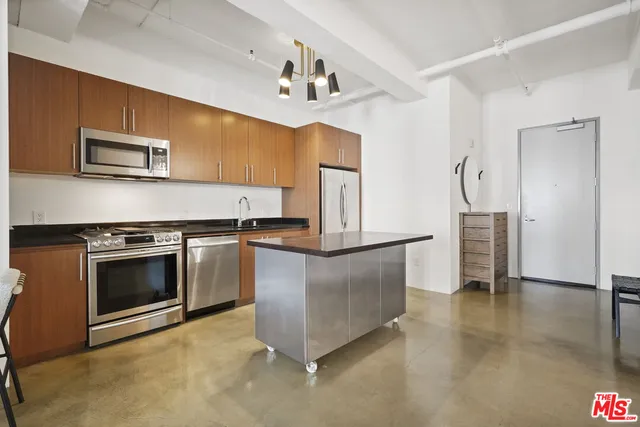 a kitchen with stainless steel appliances granite countertop a stove a refrigerator and a sink