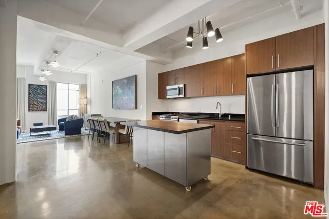 a kitchen with sink a refrigerator and chairs