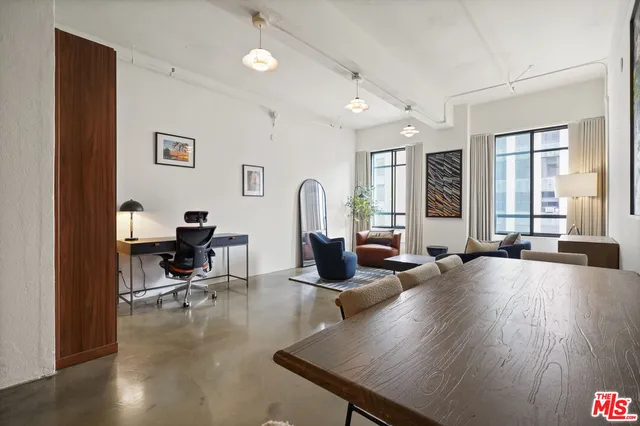 a living room with furniture a large window and wooden floor