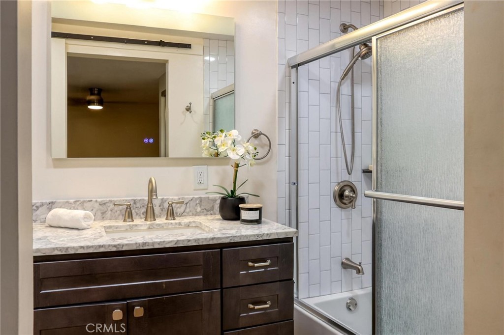 394 Pinecrest Drive Laguna Beach, CA 92651 - Photo 21 of 24 a bathroom with a granite countertop sink a shower and a mirror