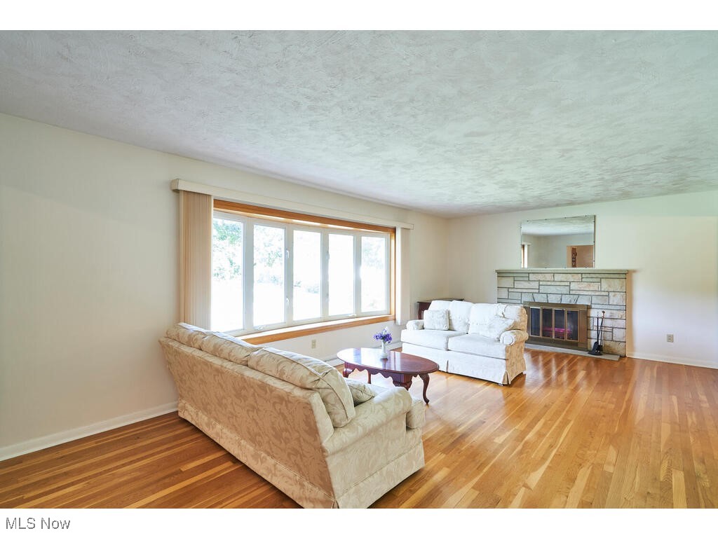 211 Benson Road Akron, OH 44333 - Photo 3 of 30 The living room is bright and cheery with a large bayed window. It also has a stone fireplace and refinished hardwood floors