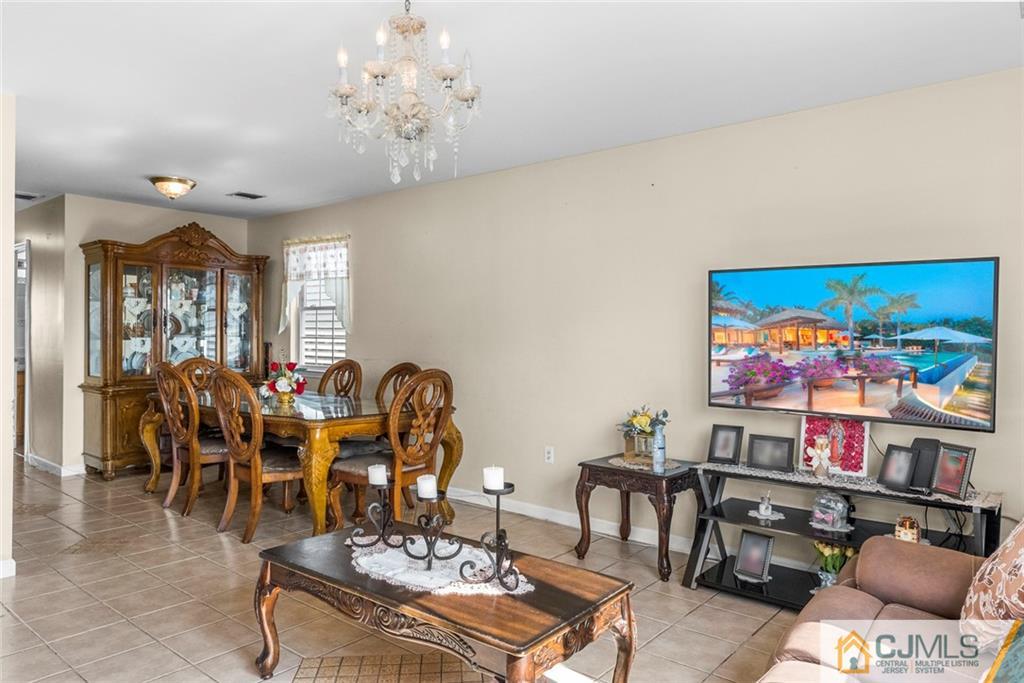 381 Prospect Street Perth Amboy, NJ 08861 - Photo 15 of 51 a view of a dining room with furniture a chandelier and wooden floor