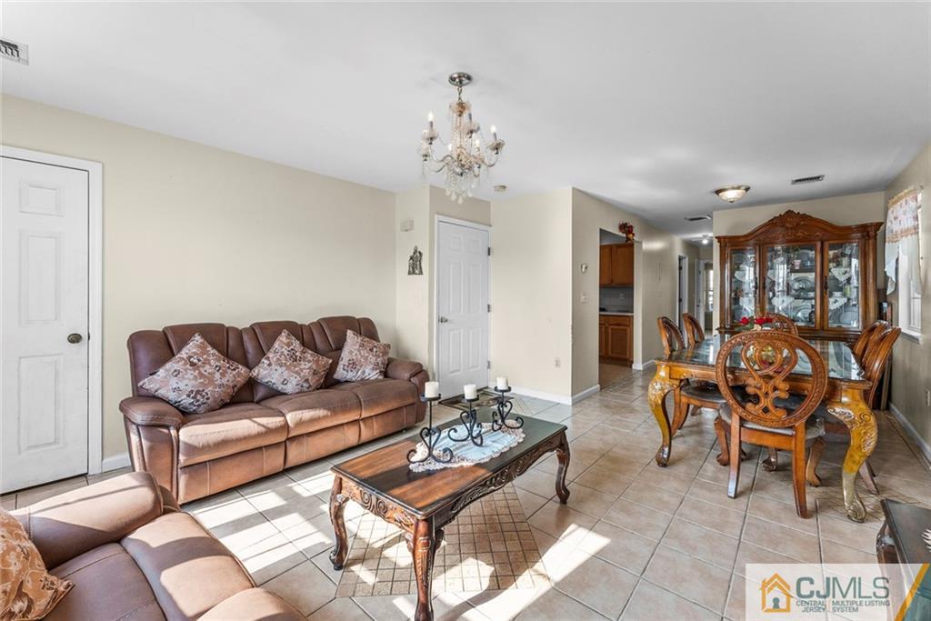 381 Prospect Street Perth Amboy, NJ 08861 - Photo 16 of 51 a living room with furniture potted plant and a chandelier