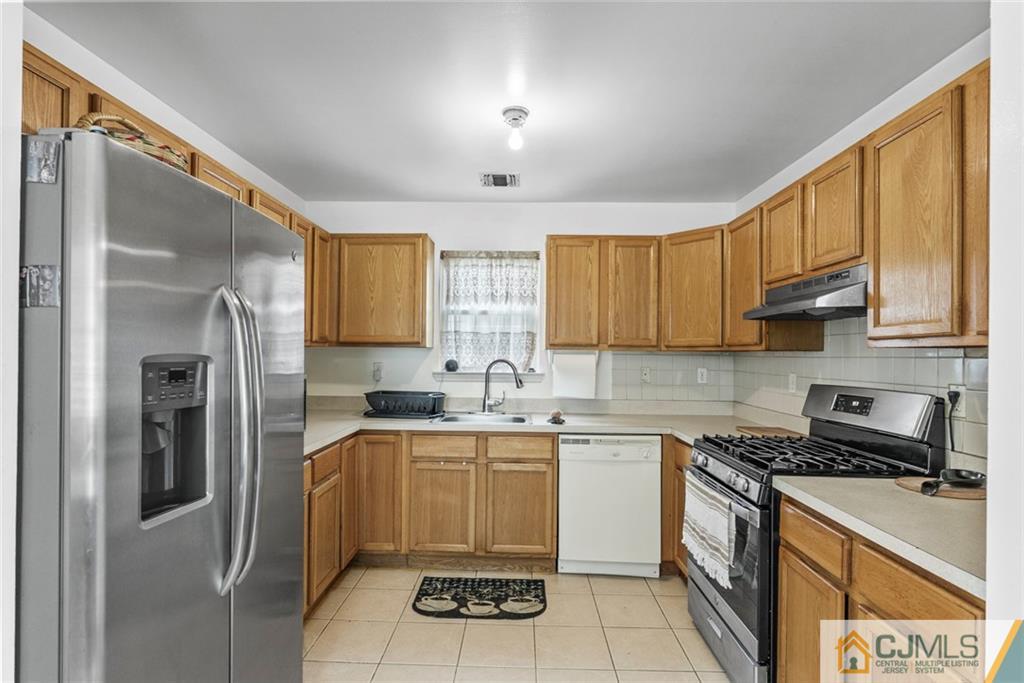 381 Prospect Street Perth Amboy, NJ 08861 - Photo 18 of 51 a kitchen with a sink a refrigerator and cabinets