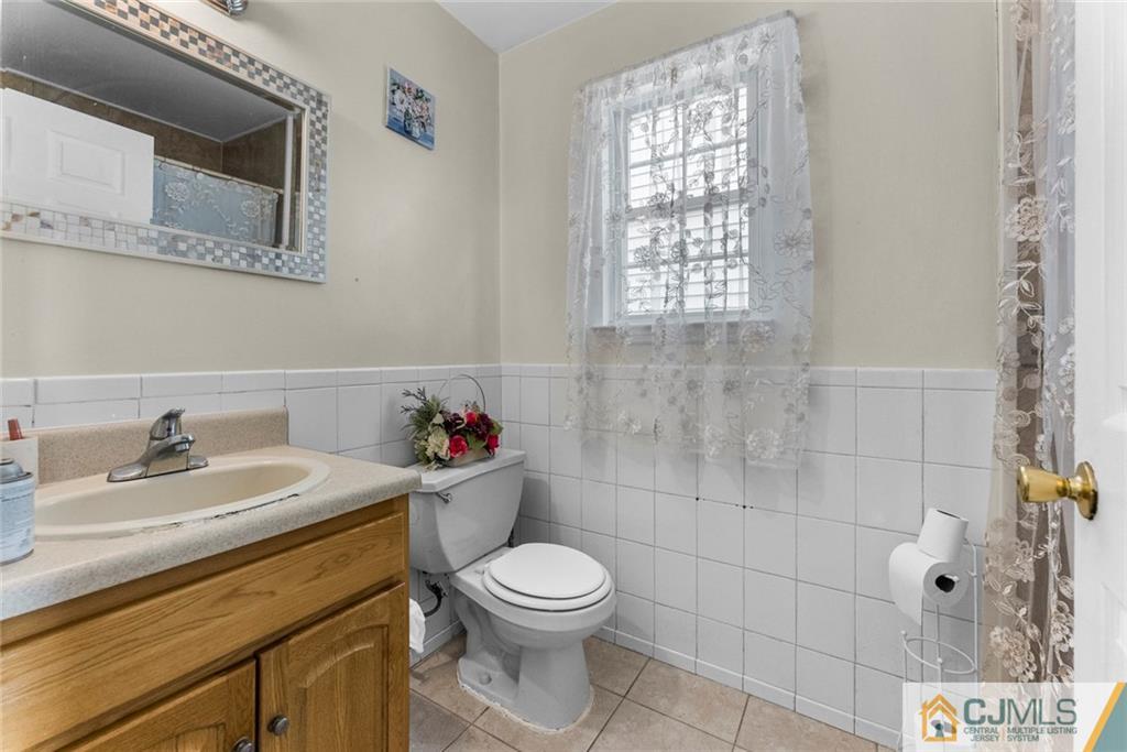381 Prospect Street Perth Amboy, NJ 08861 - Photo 21 of 51 a bathroom with a sink a toilet and a window