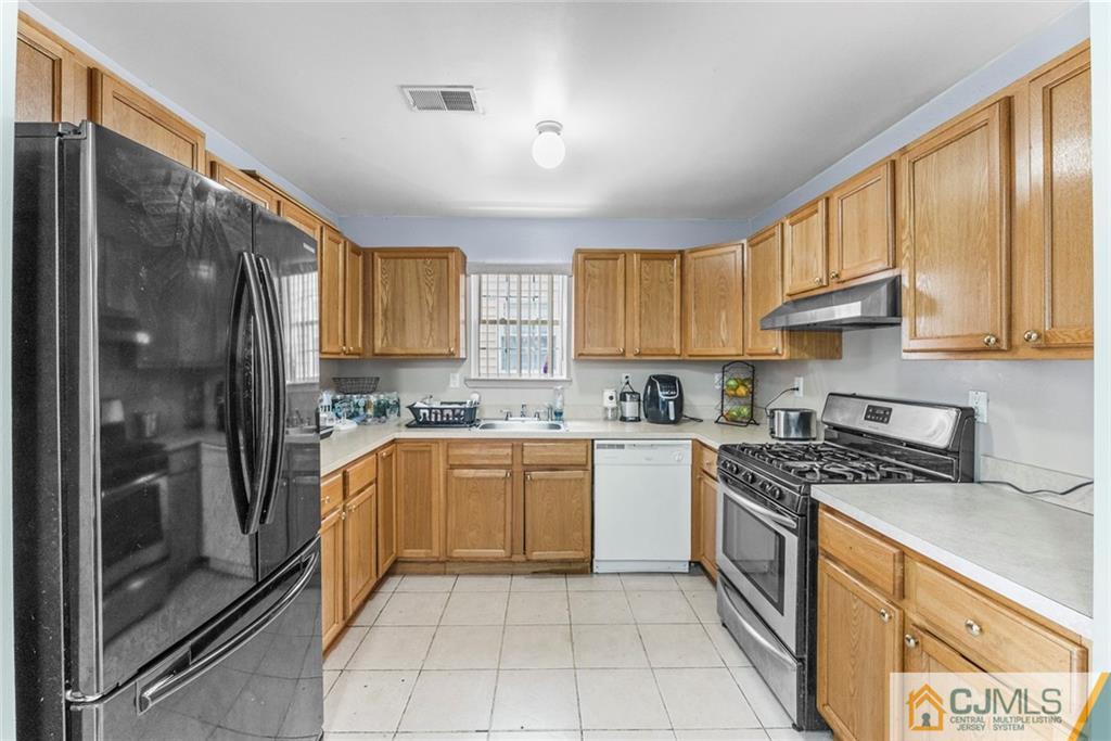381 Prospect Street Perth Amboy, NJ 08861 - Photo 34 of 51 a kitchen with stainless steel appliances granite countertop a sink stove refrigerator and cabinets