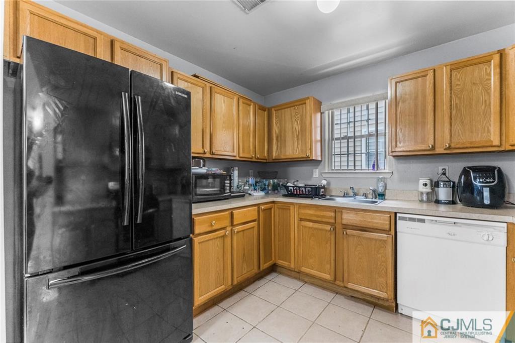 381 Prospect Street Perth Amboy, NJ 08861 - Photo 35 of 51 a kitchen with granite countertop a refrigerator and cabinets