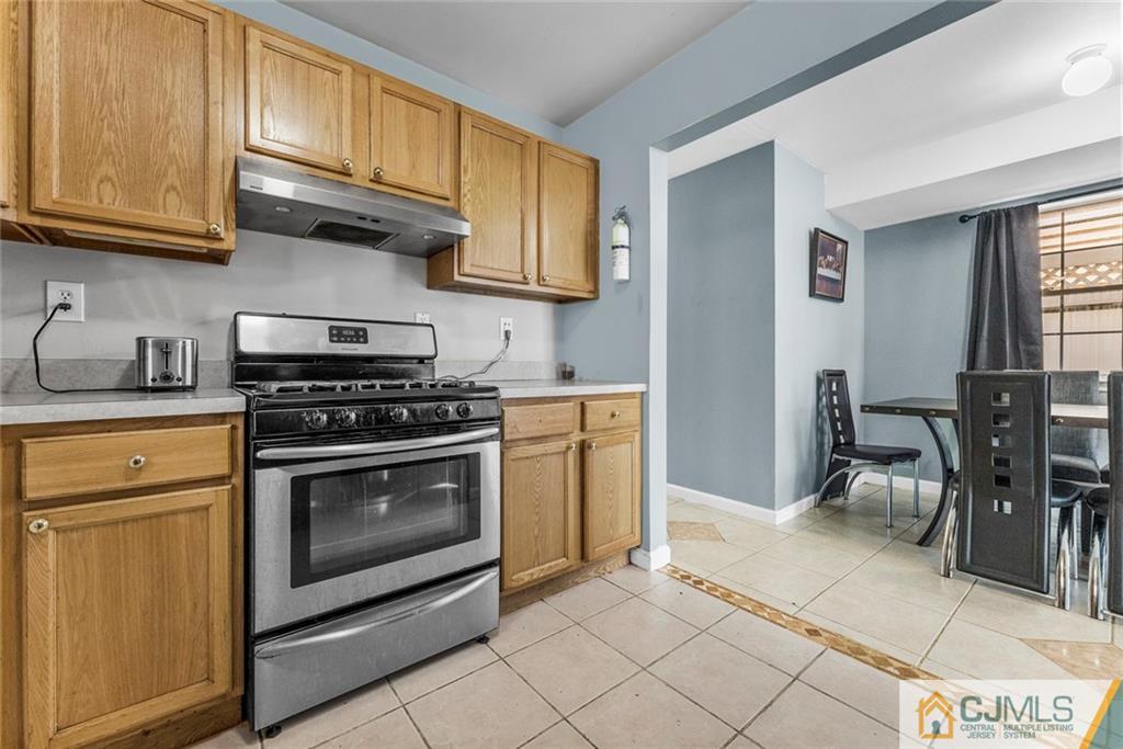 381 Prospect Street Perth Amboy, NJ 08861 - Photo 36 of 51 a kitchen with stainless steel appliances granite countertop a stove a sink and a microwave
