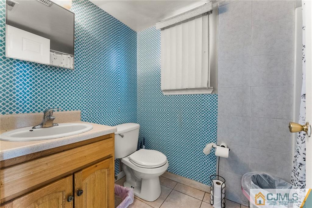 381 Prospect Street Perth Amboy, NJ 08861 - Photo 37 of 51 a bathroom with a toilet a sink and mirror