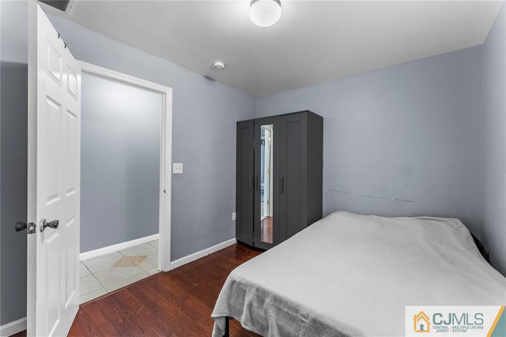 381 Prospect Street Perth Amboy, NJ 08861 - Photo 39 of 51 a bedroom with a bed and wooden floor